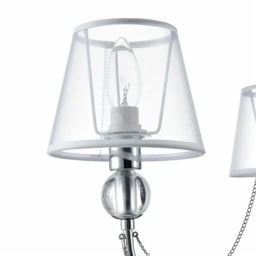 Светильники станут украшением интерьера, придадут ему шарм. Арматура светильников - из металла, а абажуры – из прозрачной органзы и ПВХ. Каждый из светильников серии дополнен тонкими серебристыми цепочками, а основания рожков украшены стеклянными прозрачн